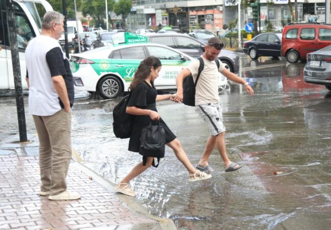 Shiu ‘pushton’ Tiranën, qytetarët kapërcejnë rrugët e mbushura plot me ujë (Foto)